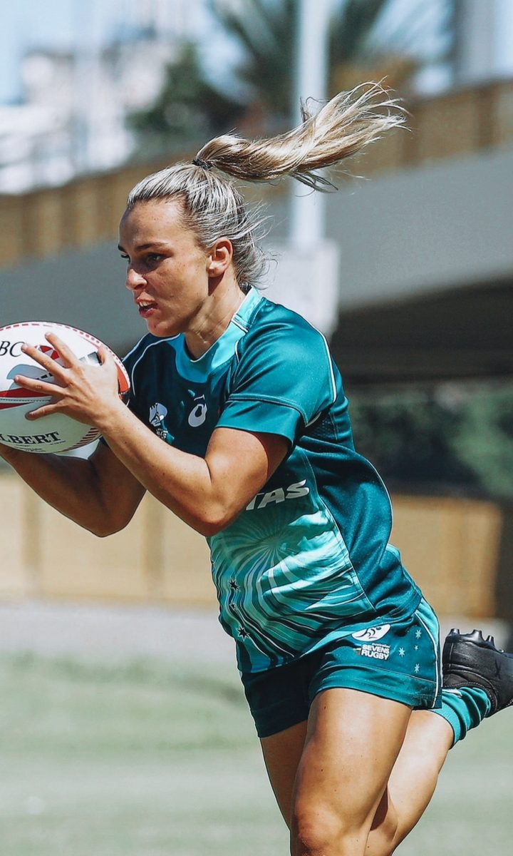 Australian Sevens rugby player breaking through a defender